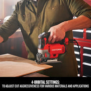 Photo of a person using a Craftsman jigsaw CMES612 to cut wood, showing 4-orbital settings feature in a workshop.