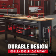 Photo of Craftsman workbench CMST27202BK with wooden top, black metal frame, drawers, loaded with tools in a garage.
