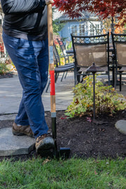 Photo of person using CRAFTSMAN lawn edger tool CMXMLTP35324 with wooden handle, edging garden next to patio.