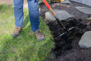 Photo of CRAFTSMAN trenching shovel CMXMLTP35324 digging soil beside stone pathway outdoors.