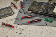A set of CRAFTSMAN precision screwdrivers are shown on a work surface with electronic components including a partially